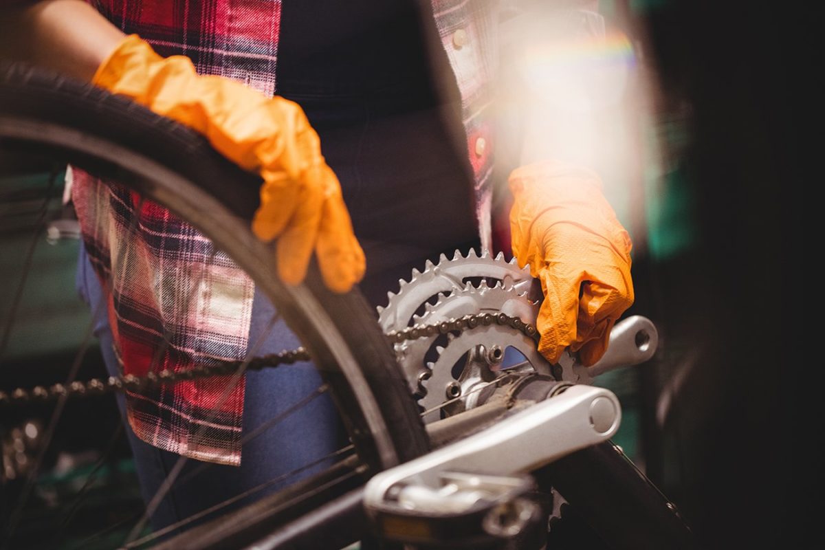 Close-up of mechanic repairing a bicycle in workshop
