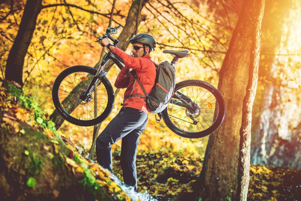 man carrying mountain bike