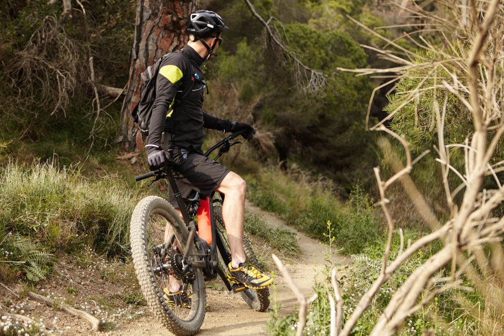 mountain biker with one food on pedal