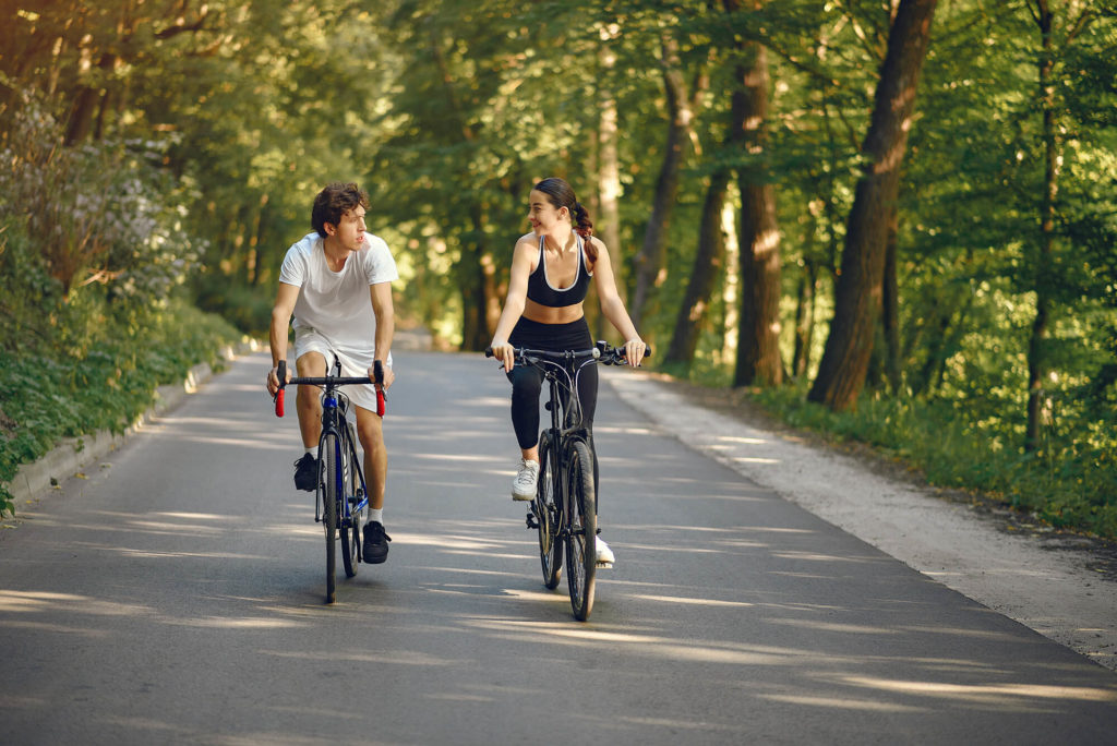 sporty couple riding bike in forest