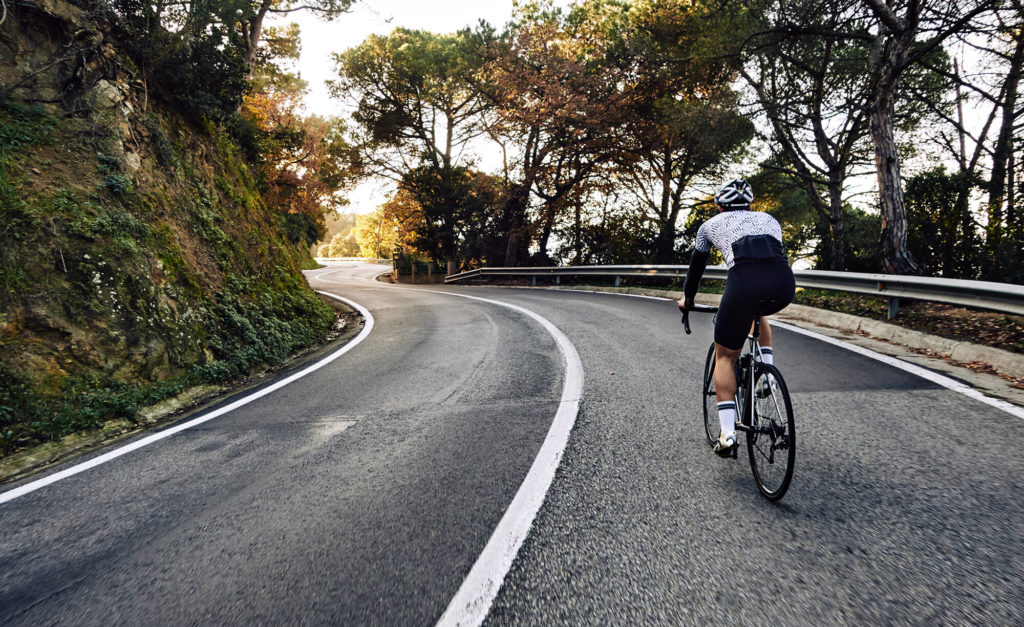 cyclist riding on hilly road