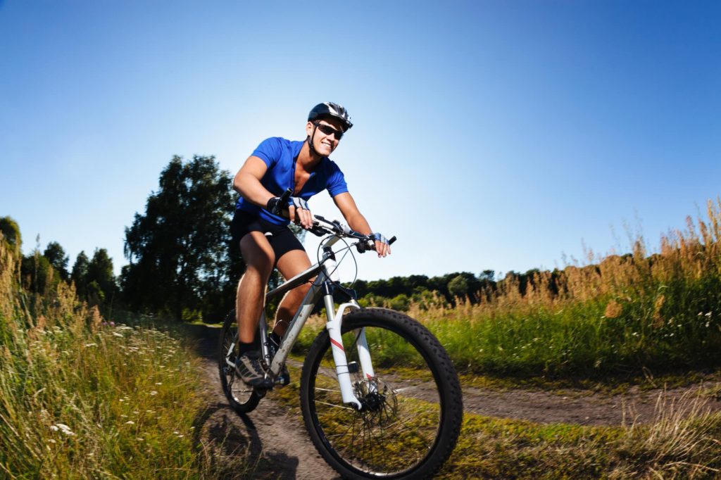 man riding hybrid bike on rough terrain