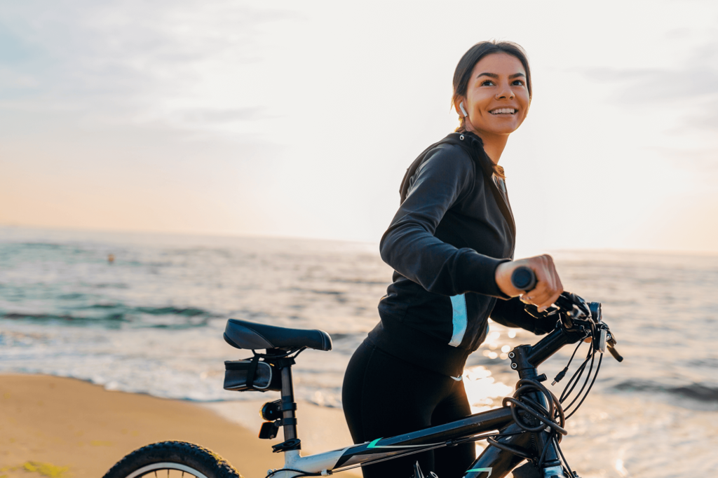 woman with bike at beach